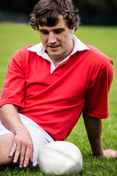 Rugby player sitting on grass — Stock Photo, Image