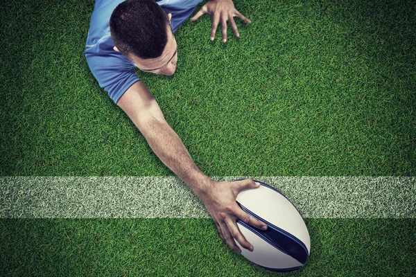 Jugador de rugby acostado en frente con la pelota — Foto de Stock