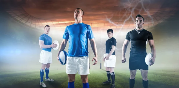 Jogadores segurando bolas de rugby — Fotografia de Stock