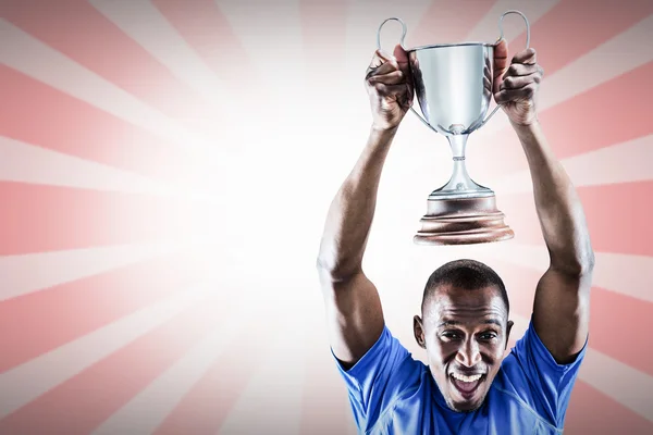 Athlete cheering while holding trophy — Stock Photo, Image