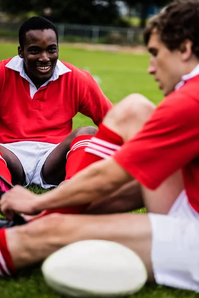 Spelarna som sitter på gräset innan match — Stockfoto