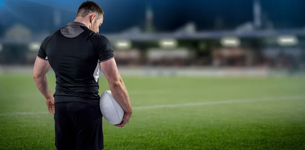 Composite image of tough rugby player holding ball — Stock Photo, Image