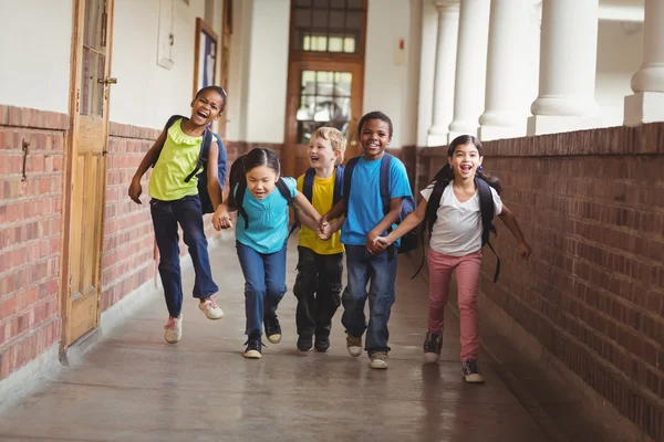 Alumnos felices tomados de la mano y corriendo — Foto de Stock