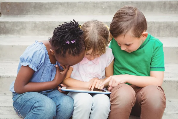 Alunos sentados em degraus e usando tablet — Fotografia de Stock