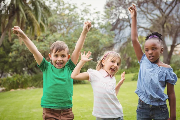 Niños celebrando con los brazos levantados —  Fotos de Stock