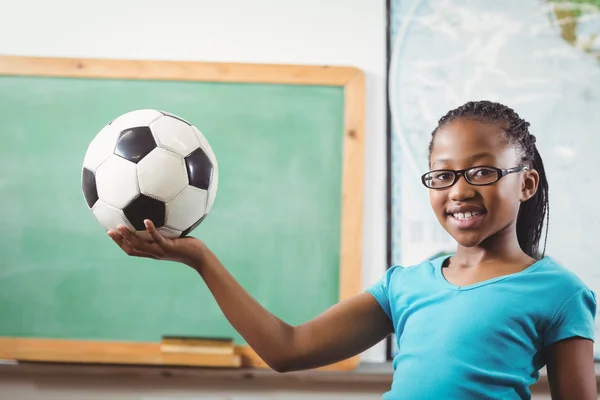 Улыбающийся ученик держит футбол — стоковое фото