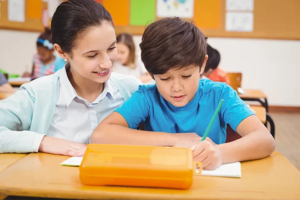 Leraar een kleine jongen helpen tijdens de les — Stockfoto