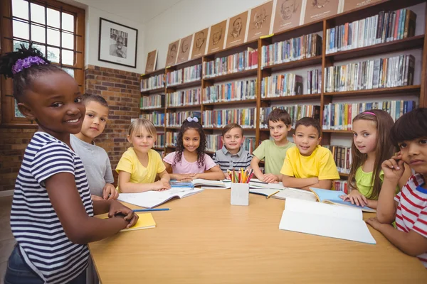 Alumnos trabajando juntos en el escritorio de la biblioteca —  Fotos de Stock