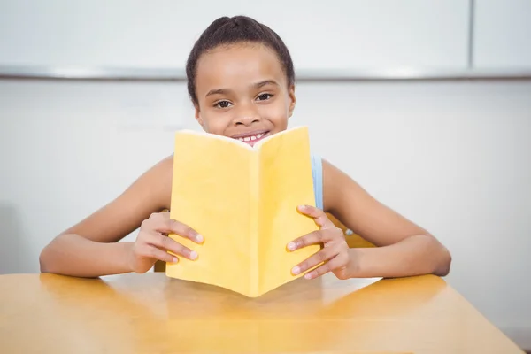 Happy pupil reading from a book — Stock Photo, Image
