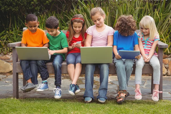 Enfants assis sur un banc de parc — Photo