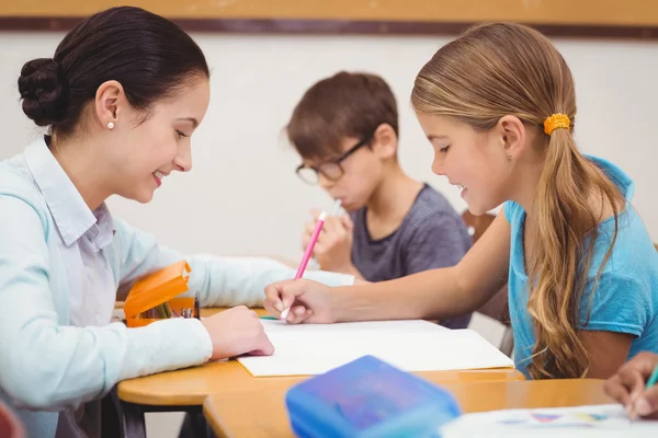 Leraar helpen een klein meisje tijdens de les — Stockfoto
