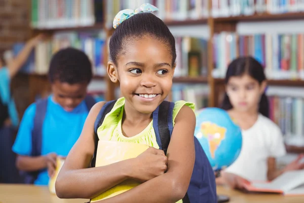 Cute pupille tenant livre dans la bibliothèque — Photo