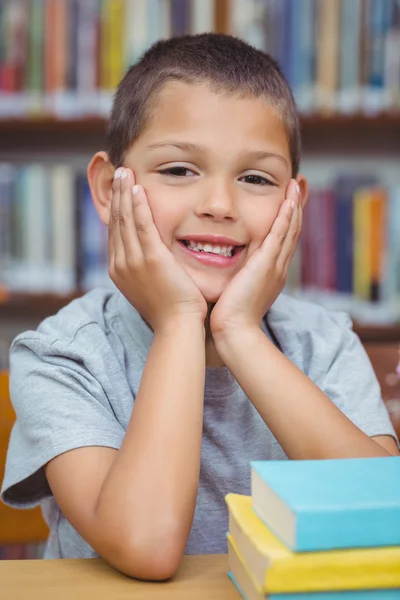 Pupila sorrindo para a câmera na biblioteca — Fotografia de Stock