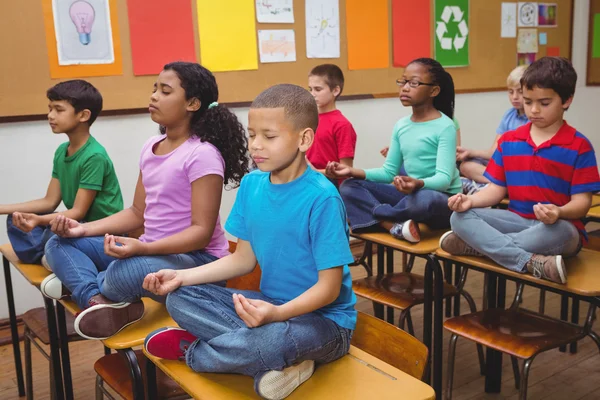 Pupils meditating on classroom desks — Stock Photo, Image