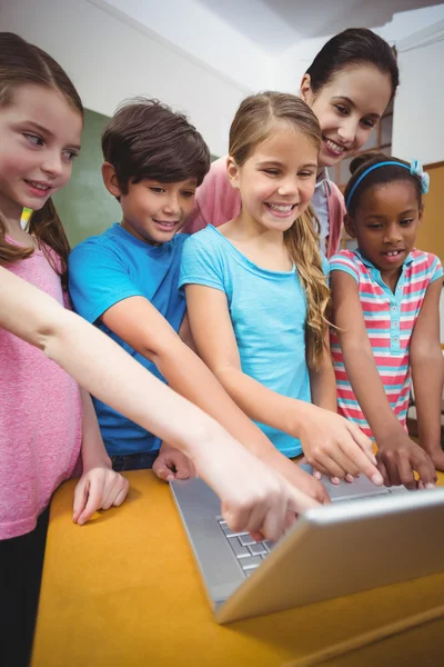 Leraar en leerlingen kijken naar laptop — Stockfoto