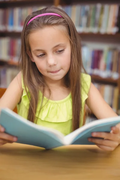 Pupil reading book at desk in library — Stock Photo, Image