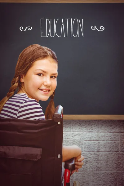 La palabra educación y niña sentada en la escuela —  Fotos de Stock