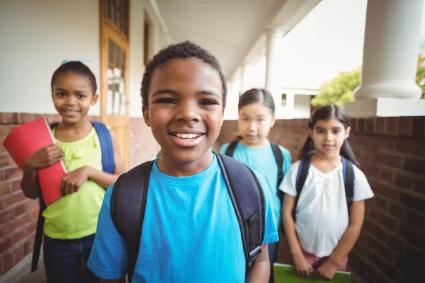 Cute pupils holding notebooks at corridor — Stock Photo, Image