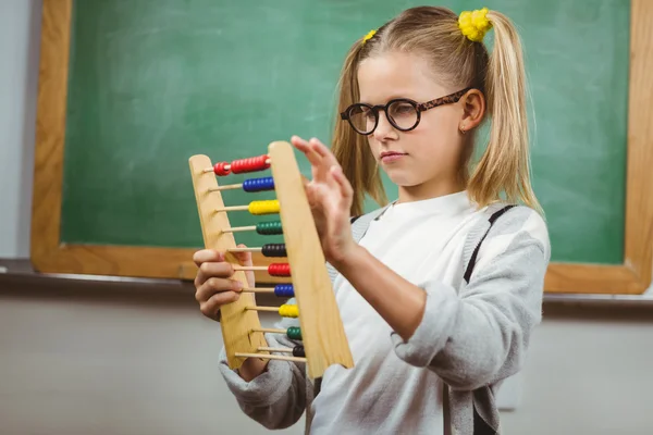Alumno lindo calculando con ábaco en un aula — Foto de Stock