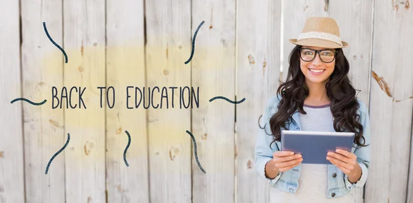 Volver a la educación contra bastante hipster sonriendo a la cámara holdi — Foto de Stock