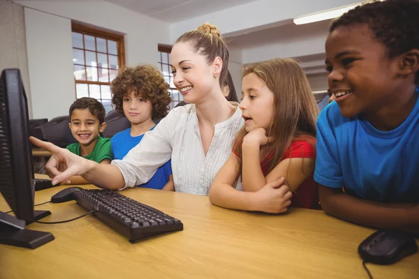 Учитель показывает учащимся, как пользоваться компьютером — стоковое фото