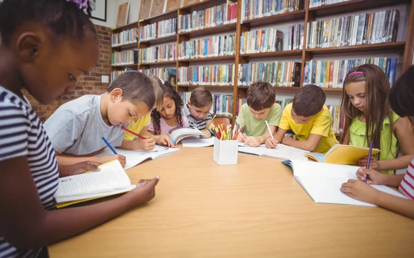 Alumnos trabajando juntos en el escritorio de la biblioteca —  Fotos de Stock