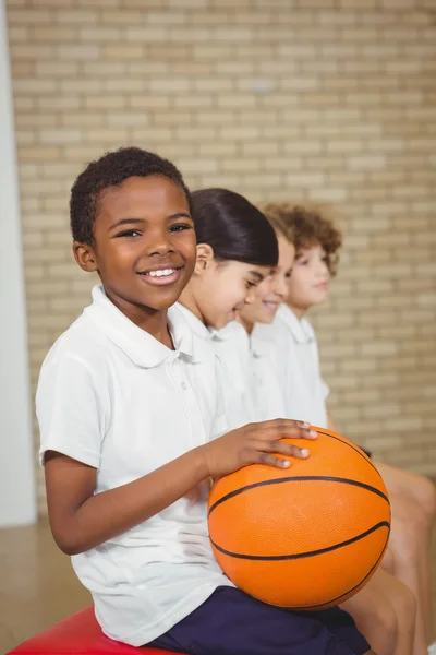 Student holding basketball with fellow players — Stock Photo, Image