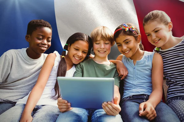 Composite image of happy children using digital tablet — Stock Photo, Image