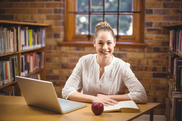 Blond lärare läsa bok i biblioteket — Stockfoto