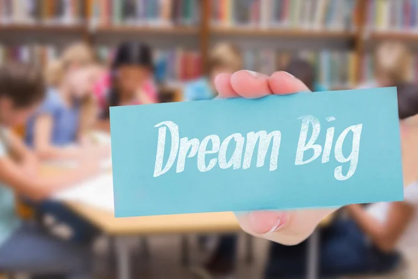 Sonho grande contra alunos bonitos escrevendo na mesa na biblioteca — Fotografia de Stock