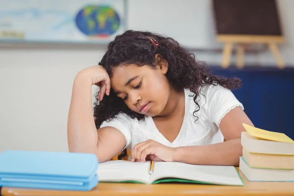 Concentrated pupil reading notepad in a classroom — Stock Photo, Image