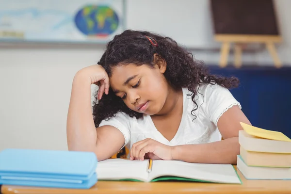 Geconcentreerde leerling lezen van Kladblok in een klaslokaal — Stockfoto