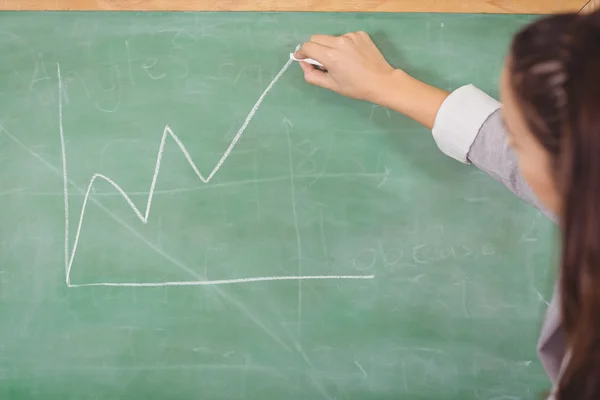 Teacher drawing graph on chalkboard — Stock Photo, Image