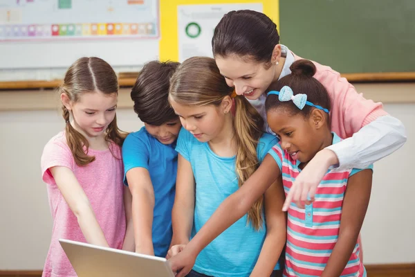 Leraar en leerlingen kijken naar laptop — Stockfoto