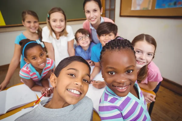 Teacher and pupils working at desk together — Stock Photo, Image