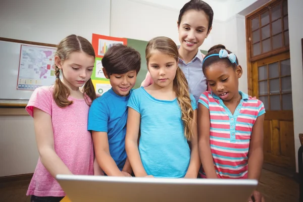 Nauczyciel i uczniowie patrząc na laptopa — Zdjęcie stockowe