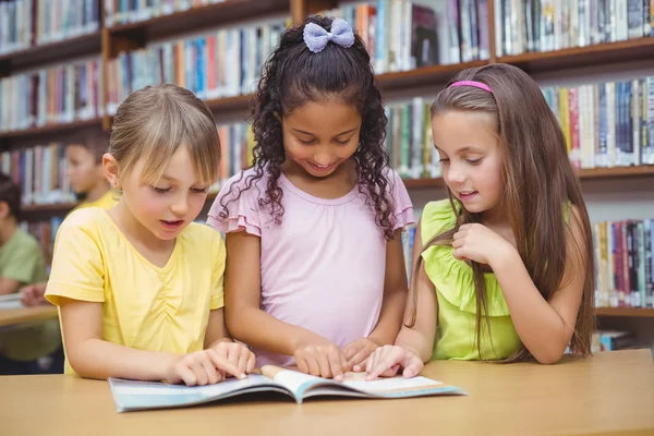 Pupils reading book together in library — Stock Photo, Image