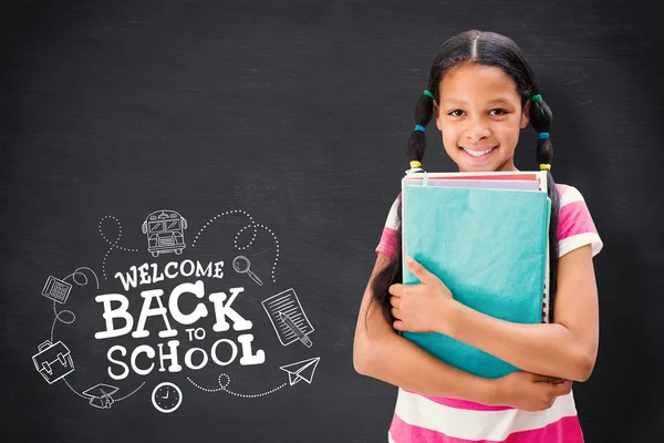 Cute pupil smiling against blackboard — Stock Photo, Image