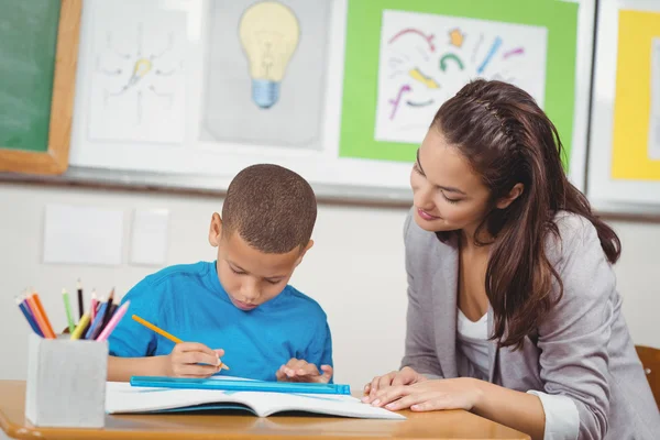 Profesor ayudando a alumno en su escritorio — Foto de Stock