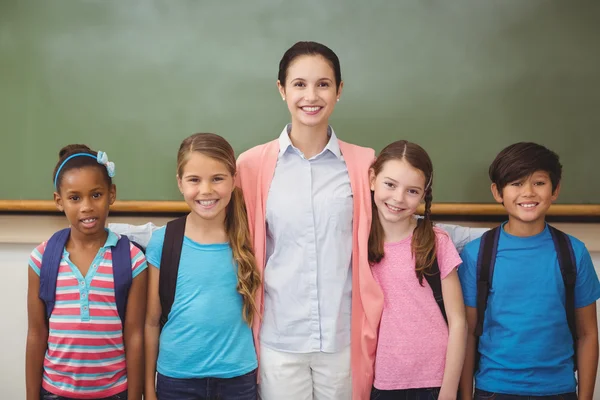 Lehrer und Schüler lächeln im Klassenzimmer in die Kamera — Stockfoto