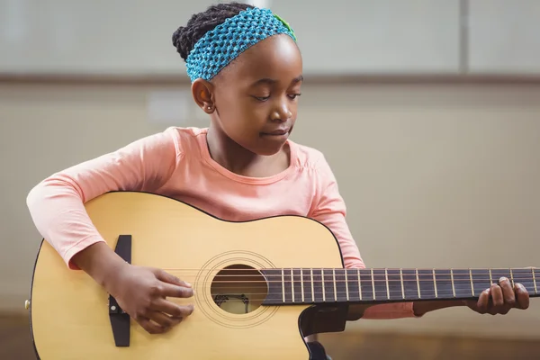 Pupil playing guitar in a classroom — Stock Photo, Image