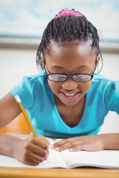 Lächelnde Schülerin am Schreibtisch — Stockfoto