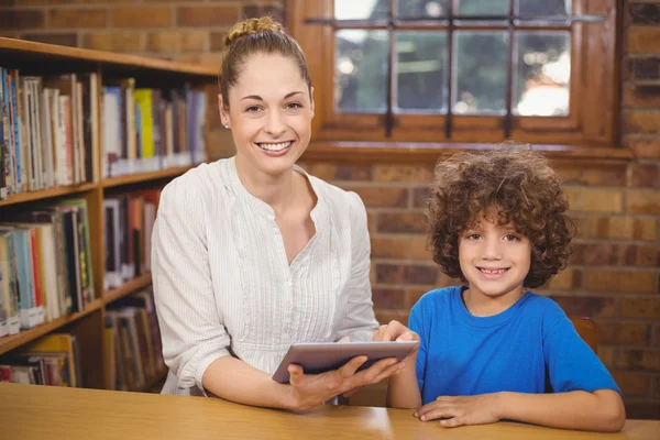 Insegnante e alunno utilizzando tablet in biblioteca — Foto Stock