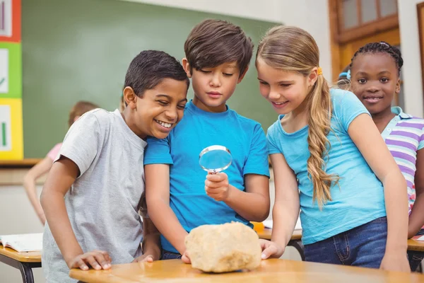 Schüler betrachten Felsen mit Lupe — Stockfoto