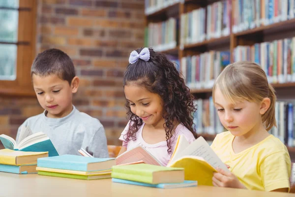 Alunos lendo livros na biblioteca — Fotografia de Stock