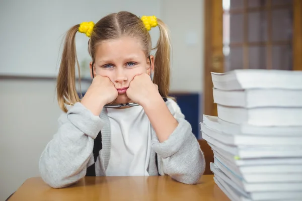 Traurige Schülerin sitzt an ihrem Schreibtisch im Klassenzimmer — Stockfoto