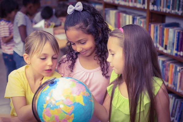 Leerlingen in bibliotheek met globe — Stockfoto