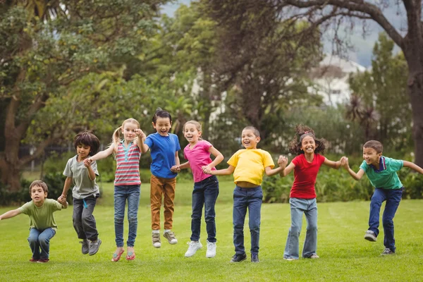 Cute pupils cheering on grass outside — Stock Photo, Image