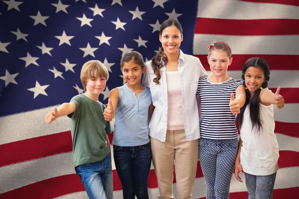 Ученики и учитель улыбаясь против флага США — стоковое фото