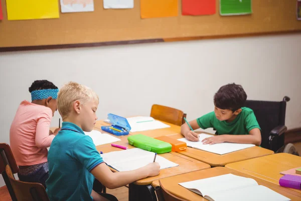 Drukke studenten die werken op het werk in klas — Stockfoto